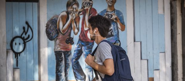 A man wears a face mask as he walks along a main street in Tel Aviv, Israel, Sunday, March 15, 2020 - Sputnik International