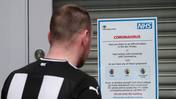 Soccer Football - Premier League - Coronavirus impact on the Premier League - St James' Park, Newcastle, Britain - March 14, 2020  A fan reads a NHS sign outside St James' Park as the Premier League is suspended due to the number of coronavirus cases growing around the world  - Sputnik International