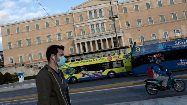 A man wearing a protective face mask walks past the parliament building in Athens, Greece - Sputnik International