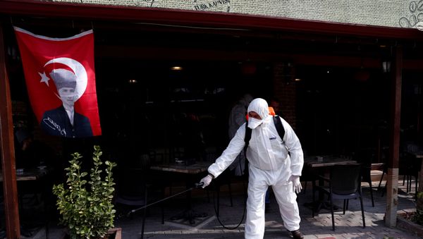 A municipality worker wearing protective suit sanitises a coffee shop in Karaagac district against the coronavirus disease (COVID-19) near Turkey's Pazarkule border crossing with Greece's Kastanies, in Edirne, Turkey, March 10, 2020 - Sputnik International
