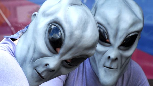 Two aliens pose for a photograph in front of Imagine That Scrapbooks on Main Street in downtown Roswell, N.M., Friday, July 6, 2007, during the UFO Festival - Sputnik International