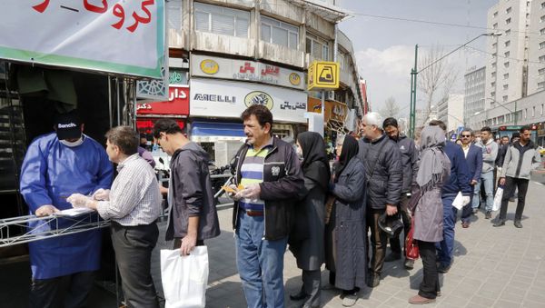 People queue in line to receive packages for precautions against COVID-19 coronavirus disease provided by the Basij, a militia loyal to Iran's Islamic republic establishment, from a booth outside Meydane Valiasr metro station in the capital Tehran on March 15, 2020. - Iran on March 15 announced that the new coronavirus has killed 113 more people, the highest single-day death toll yet in one of the world's worst-affected countries. - Sputnik International
