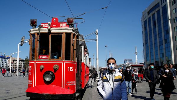 People wearing protective face masks, due to coronavirus disease (COVID-19) concerns, walk at Taksim square in central Istanbul, Turkey, March 17, 2020 - Sputnik International