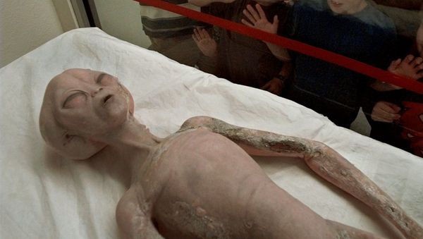 Children eye a model of an alien on display inside the International UFO Museum and Research Center in Roswell, N.M., Monday, June 9, 1997 - Sputnik International