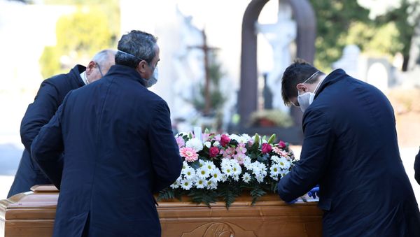 Cemetery workers and funeral agency workers in protective masks transport a coffin of a person who died from coronavirus disease (COVID-19), into a cemetery in Bergamo, Italy March 16, 2020. - Sputnik International