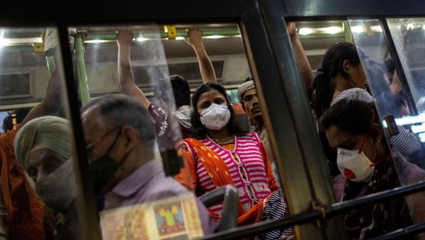 Commuters wearing protective masks as a precaution against the spread of coronavirus disease (COVID-19), travel in a crowded bus during evening rush hour, in New Delhi, India, March 18, 2020.  - Sputnik International