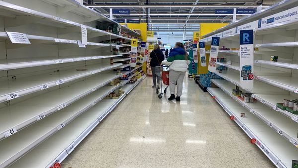 Shoppers walk past empty shelves inside a Tesco supermarket, during the coronavirus disease (COVID-19) outbreak, in Liverpool, Britain, March 18, 2020. - Sputnik International