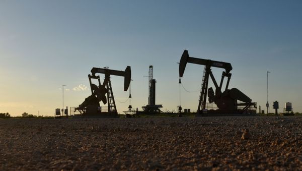Pump jacks operate in front of a drilling rig in an oil field in Midland, Texas U.S. August 22, 2018. Picture taken August 22, 2018. - Sputnik International