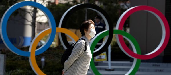 FILE PHOTO: A woman wearing a protective face mask, following an outbreak of the coronavirus disease (COVID-19), walks past the Olympic rings in front of the Japan Olympics Museum in Tokyo, Japan March 13, 2020 FILE PHOTO: A woman wearing a protective face mask, following an outbreak of the coronavirus disease (COVID-19), walks past the Olympic rings in front of the Japan Olympics Museum in Tokyo, Japan March 13, 2020 - Sputnik International