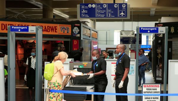 Immigration workers wear protective masks at a departure port at Robert Mugabe International airport in Harare, Zimbabwe, March 11, 2020. Picture taken March 11, 2020. - Sputnik International