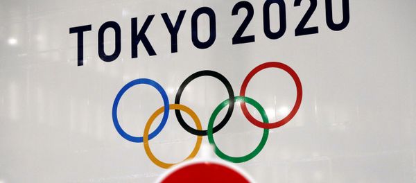 A banner for the upcoming Tokyo 2020 Olympics is seen behind a traffic sign, following an outbreak of the coronavirus disease (COVID-19), in Tokyo, Japan, March 23, 2020.  - Sputnik International