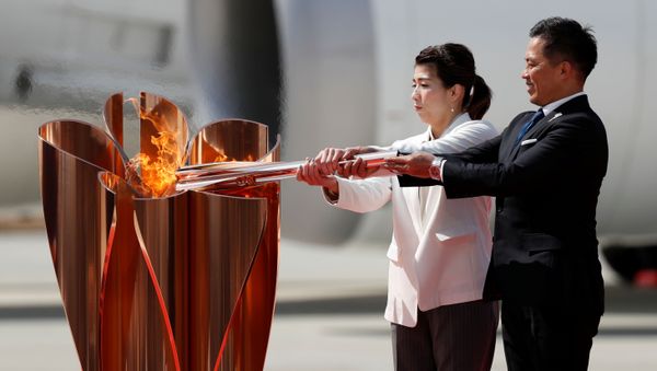 Three-time Olympic gold medalists Tadahiro Nomura and Saori Yoshida light the Olympic Flame at the Olympic cauldron during a ceremony at Japan Air Self-Defense Force Matsushima Base in Higashi-Matsuhsima, Miyagi prefecture, northern Japan March 20, 2020 - Sputnik International