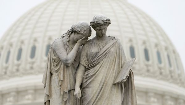 Grief holds her covered face against the shoulder of History and weeps in mourning as depicted at the Peace Monument in front of the U.S. Capitol in Washington, U.S., March 23, 2020.  The U.S. Senate struggled to reach agreement on a far-reaching coronavirus stimulus package on Monday. - Sputnik International