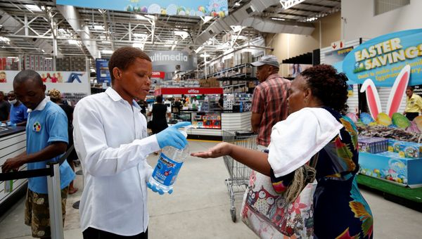 A store assistant gives people hand sanitiser as shoppers stock up on groceries at a Makro Store ahead of a nationwide 21 day lockdown in an attempt to contain the coronavirus disease (COVID-19) outbreak in Durban, South Africa, March 24, 2020. - Sputnik International