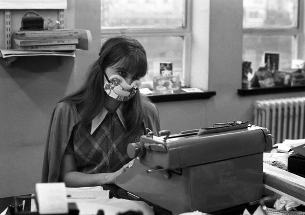 An office worker wearing an anti-flu mask sits at her type-writer in London, on January 1, 1970. An office worker wearing an anti-flu mask sits at her type-writer in London, on January 1, 1970. - Sputnik International