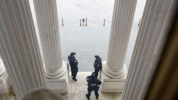 U.S. Capitol Police officers stand atop of the U.S. Senate stairway, ahead of a vote on the coronavirus relief bill, on Capitol Hill in Washington, U.S., March 25, 2020.  - Sputnik International