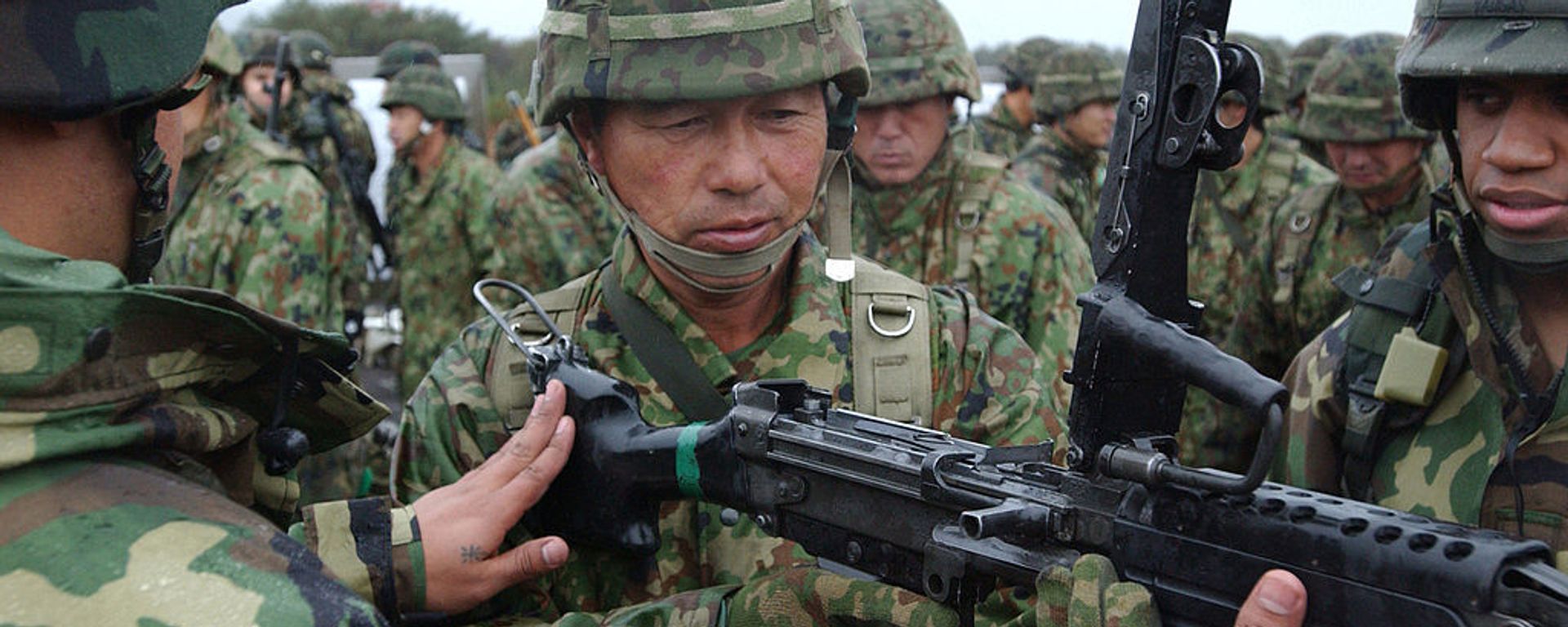American Soldiers demonstrate the M-249 Squad Automatic Weapon to a Japanese soldier of the 39th Infantry Regiment, Japan Ground Self-Defense Force, during Exercise Orient Shield - Sputnik International, 1920, 21.03.2025