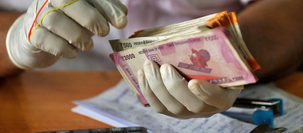 A trader wearing protective hand gloves counts Indian currency notes at a market during a 21-day nationwide lockdown to limit the spreading of coronavirus disease (COVID-19), in Kochi, India, March 27, 2020. A trader wearing protective hand gloves counts Indian currency notes at a market during a 21-day nationwide lockdown to limit the spreading of coronavirus disease (COVID-19), in Kochi, India, March 27, 2020. - Sputnik International