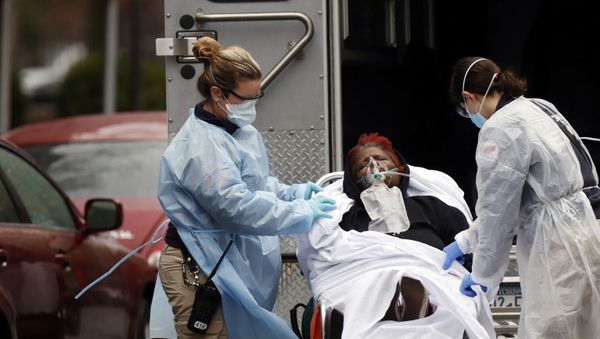 Emergency Medical Technicians (EMT) wearing protective gears wheel a sick patient to a waiting ambulance during the outbreak of coronavirus disease (COVID-19) in New York City, New York, U.S. - Sputnik International