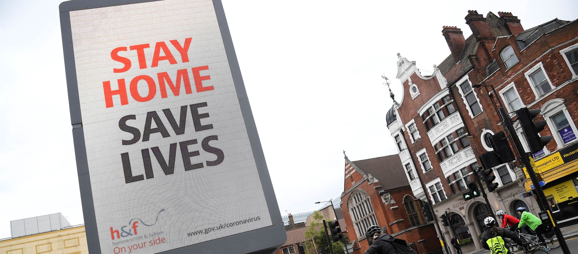 Cyclists pass an electronic billboard displaying a Public health information campaign message from the UK government and local government in London as the spread of the coronavirus disease (COVID-19) continues, London, Britain, March 28, 2020. - Sputnik International, 1920, 17.04.2020