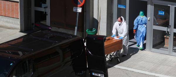 A funeral worker wearing a protective suit carries a coffin out of the morgue at Severo Ochoa Hospital, during the coronavirus disease (COVID-19) outbreak in Leganes, Spain, March 26, 2020 - Sputnik International