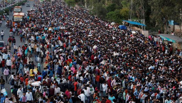  Migrant workers crowd up outside a bus station as they wait to board buses to return to their villages during a 21-day nationwide lockdown to limit the spreading of coronavirus disease (COVID-19), in Ghaziabad, on the outskirts of New Delhi, India March 28, 2020 - Sputnik International