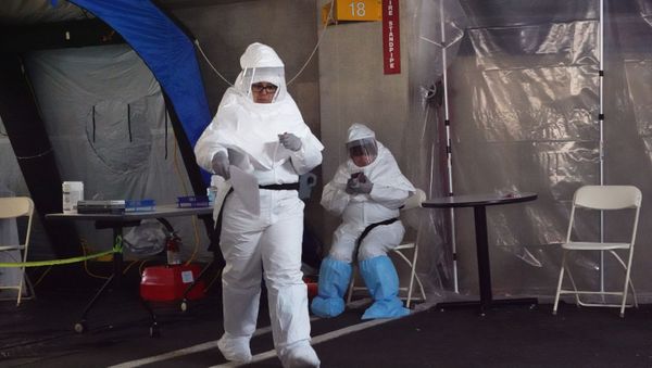 Medical personnel wear protective gear while working at a drive-through testing site for coronavirus disease (COVID-19) in Greenwich, Connecticut, U.S.,March 27, 2020 - Sputnik International