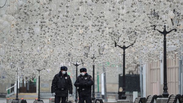 Russian law enforcement officers wearing protective masks stand guard in a street, after the city authorities announced a partial lockdown ordering residents to stay at home to prevent the spread of coronavirus disease (COVID-19), in central Moscow, Russia March 30, 2020 - Sputnik International