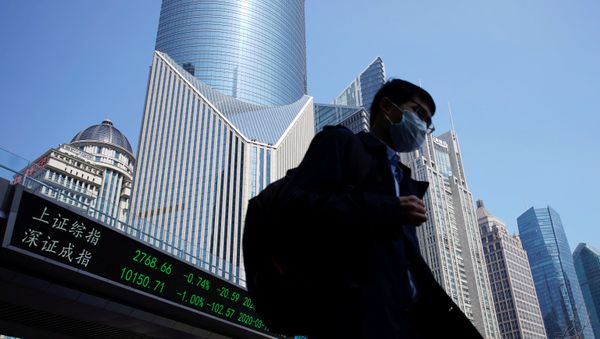 A pedestrian wearing a face mask walks near an overpass with an electronic board showing stock information, following an outbreak of the coronavirus disease (COVID-19), at Lujiazui financial district in Shanghai, China March 17, 2020. A pedestrian wearing a face mask walks near an overpass with an electronic board showing stock information, following an outbreak of the coronavirus disease (COVID-19), at Lujiazui financial district in Shanghai, China March 17, 2020. - Sputnik International