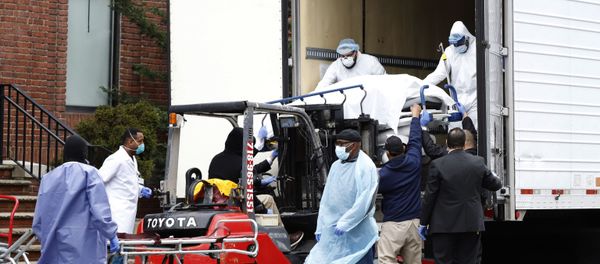 Workers load deceased person into truck trailer outside Brooklyn Hospital Center during the coronavirus disease (COVID-19) in New York - Sputnik International