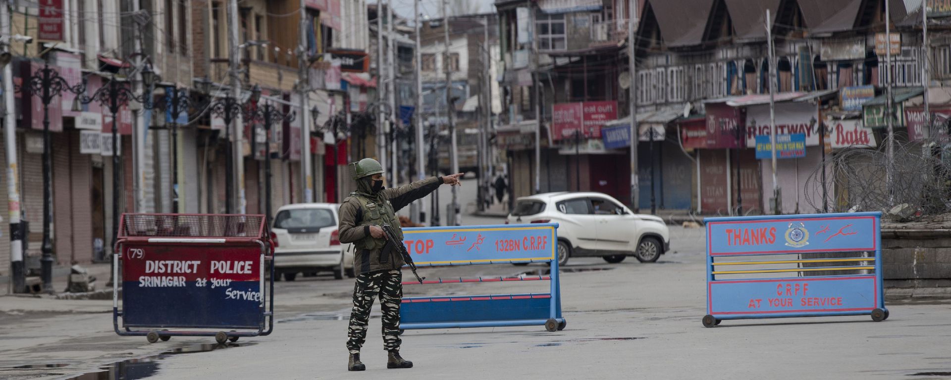 An Indian paramilitary soldier gestures towards a Kashmiri man during lockdown in Srinagar, Indian controlled Kashmir, Wednesday, March 25, 2020 An Indian paramilitary soldier gestures towards a Kashmiri man during lockdown in Srinagar, Indian controlled Kashmir, Wednesday, March 25, 2020 - Sputnik International, 1920, 21.09.2021