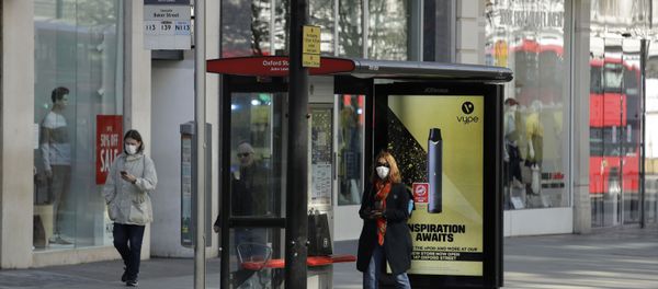 A woman waits at a bus stop in London's deserted Oxford Street A woman waits at a bus stop in London's deserted Oxford Street - Sputnik International
