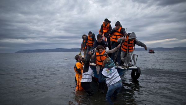 In this Thursday, Dec. 3, 2015 photo, volunteers help refugees disembark from a vessel carrying Yazidi refugee Samir Qasu, 45, from Sinjar, Iraq, and his wife Bessi, 42, their two daughters Delphine, 18, seen center left,  Dunia 13, and their two sons Dilshad, 17, seen center left, and Dildar, 10, as it arrives to the northeastern Greek island of Lesbos from the Turkish coast. - Sputnik International