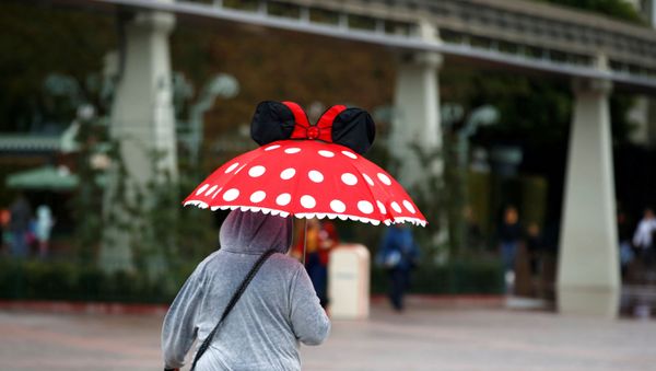 A person walks by Disneyland theme park in Anaheim, California, U.S., March 13, 2020 - Sputnik International