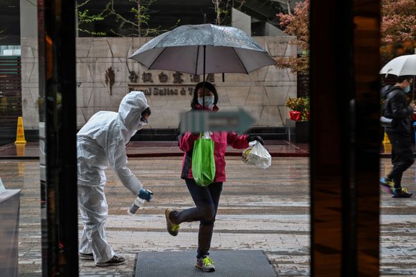 A hotel employee wearing a protective suit sprays disinfectant on an arriving guest, as a preventative measure against the COVID-19 coronavirus in Wuhan, China's central Hubei province on March 29, 2020, a day after travel restrictions into the city were eased following the outbreak A hotel employee wearing a protective suit sprays disinfectant on an arriving guest, as a preventative measure against the COVID-19 coronavirus in Wuhan, China's central Hubei province on March 29, 2020, a day after travel restrictions into the city were eased following the outbreak - Sputnik International