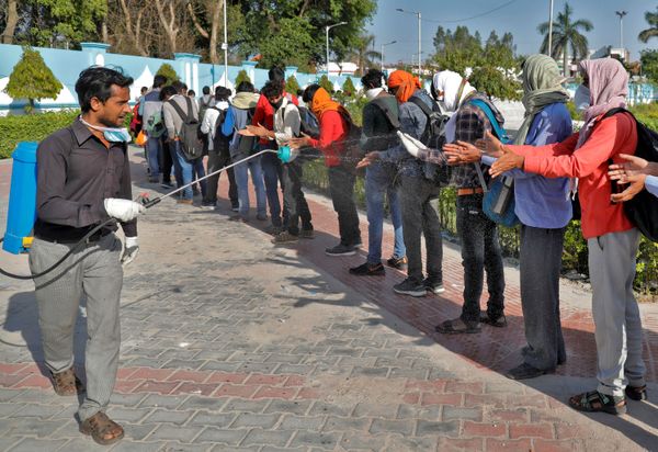 A municipal worker sprays disinfectant on migrant workers before they board a bus to return to their villages, during a 21-day nationwide lockdown to slow the spread of coronavirus disease (COVID-19), in Lucknow, India, March 30, 2020 A municipal worker sprays disinfectant on migrant workers before they board a bus to return to their villages, during a 21-day nationwide lockdown to slow the spread of coronavirus disease (COVID-19), in Lucknow, India, March 30, 2020 - Sputnik International