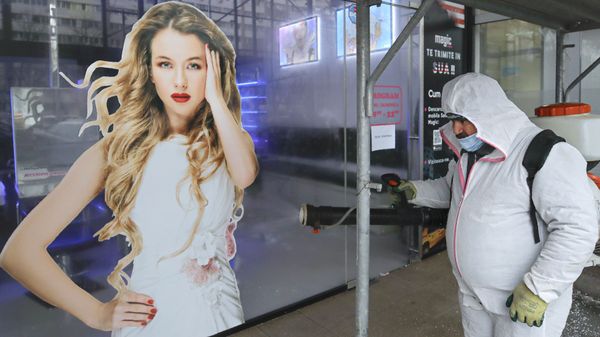 A municipal worker wearing a protective outfit passes by hairdresser shop while spraying chemicals during the disinfection of an area of the Romanian capital Bucharest, Romania, Tuesday, March 31, 2020 as authorities attempt to limit the spread of the new coronavirus A municipal worker wearing a protective outfit passes by hairdresser shop while spraying chemicals during the disinfection of an area of the Romanian capital Bucharest, Romania, Tuesday, March 31, 2020 as authorities attempt to limit the spread of the new coronavirus - Sputnik International