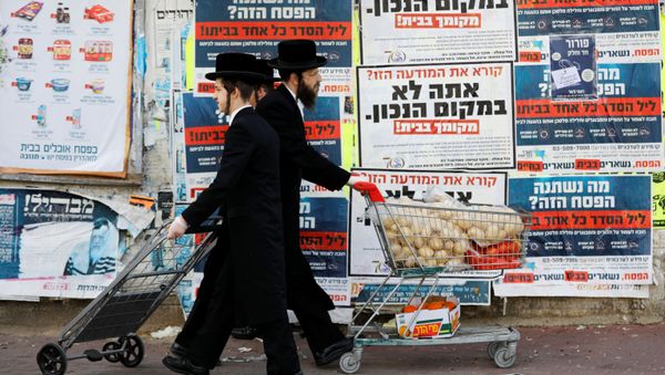 Ultra-Orthodox Jewish men push trolleys as they pass by billboards urging people to stay in their homes and keeping with government restrictions amid coronavirus disease (COVID-19) in Ashdod, Israel  April 1, 2020 - Sputnik International
