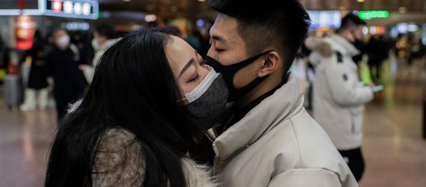 A couple, wearing protective masks, kisses goodbye as they travel for the Lunar New Year holidays, at Beijing West Railway Station in Beijing on January 24, 2020 A couple, wearing protective masks, kisses goodbye as they travel for the Lunar New Year holidays, at Beijing West Railway Station in Beijing on January 24, 2020 - Sputnik International
