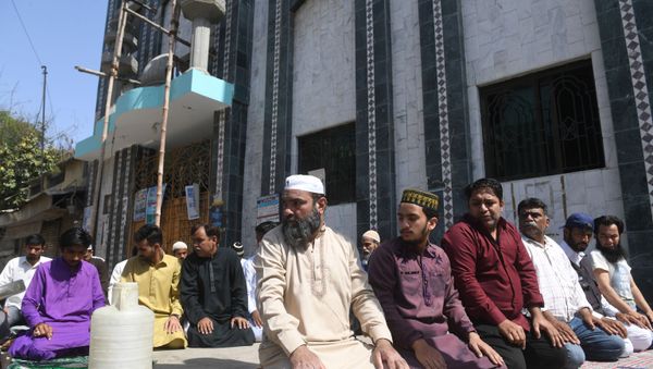 Muslim devotees offer Friday prayers outside a closed mosque alongside a street during a government-imposed nationwide lockdown as a preventive measure against the COVID-19 coronavirus, in Karachi on April 3, 2020. - Sputnik International