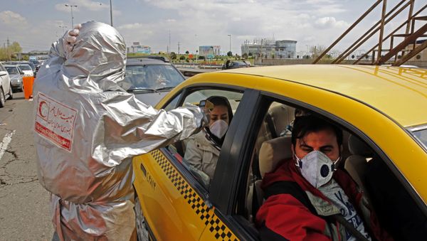 Members of the Iranian Red Crescent test people for coronavirus Covid-19 symptoms, as police blocked Tehran to Alborz highway to check every car following orders by the Iranian government, outside Tehran on March 26, 2020 - Sputnik International