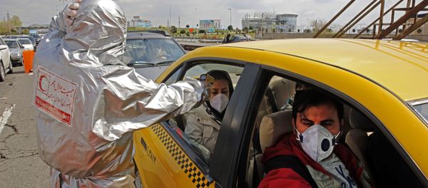 Members of the Iranian Red Crescent test people for coronavirus Covid-19 symptoms, as police blocked Tehran to Alborz highway to check every car following orders by the Iranian government, outside Tehran on March 26, 2020 - Sputnik International
