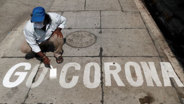 A man paints a message on a street after India ordered a 21-day nationwide lockdown to limit the spreading of coronavirus disease (COVID-19) in Mumbai, India, 28 March 2020.  - Sputnik International