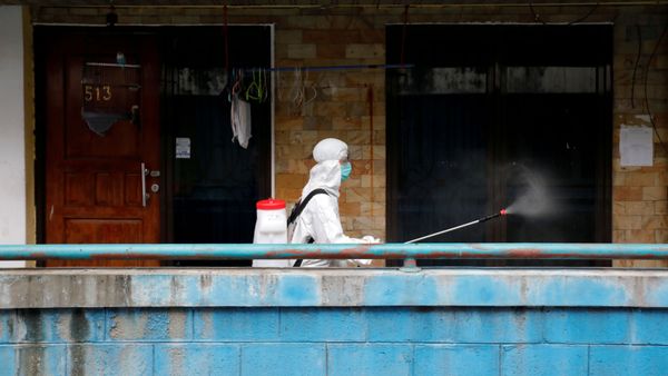 A Red Cross personnel wearing a protective suit sprays disinfectant along a corridor in a densely populated neighbourhood area, amid the spread of the coronavirus disease (COVID-19) in Jakart A Red Cross personnel wearing a protective suit sprays disinfectant along a corridor in a densely populated neighbourhood area, amid the spread of the coronavirus disease (COVID-19) in Jakart - Sputnik International