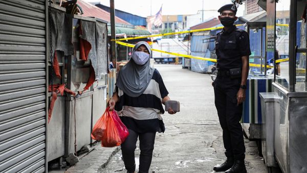 A police officer stands guard at an entrance of a market, during the movement control order due to the outbreak of the coronavirus disease (COVID-19), in Kuala Lumpur A police officer stands guard at an entrance of a market, during the movement control order due to the outbreak of the coronavirus disease (COVID-19), in Kuala Lumpur - Sputnik International