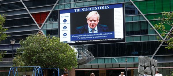 Workers take their lunch outdoors as a screen giving information about British Prime Minister Boris Johnson is seen on the background on the first day of circuit breaker measures to curb coronavirus (COVID-19) at the central business district in Singapore, April 7, 2020 - Sputnik International