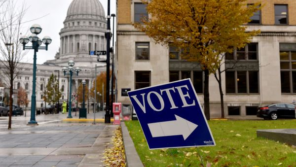 A sign directs voters towards a polling place near the state capitol in Madison, Wisconsin, U.S. November 6, 2018 - Sputnik International