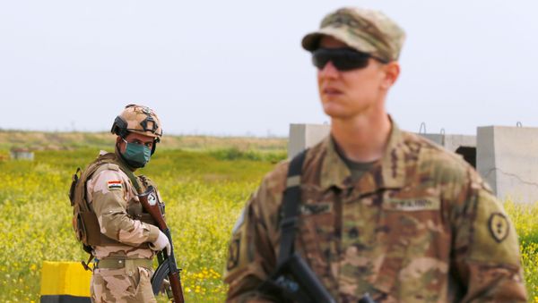 An Iraqi soldier wears a protective face mask and gloves, following the outbreak of coronavirus disease (COVID-19),  as he stands guard during the hand over of Qayyarah Airfield West from US-led coalition forces to Iraqi Security Forces, in the south of Mosul, Iraq March 26, 2020. - Sputnik International