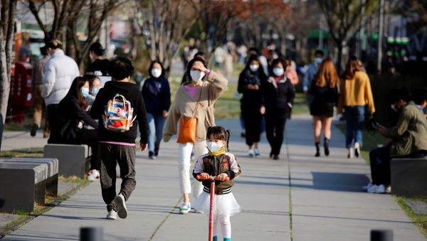 A girl wearing a protective face mask to prevent contracting the coronavirus disease (COVID-19) rides a toy kick scooter at a park in Seoul, South Korea, April 3, 2020 - Sputnik International