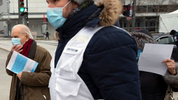 A man is escorted by healthcare workers to be tested as the city's public health unit holds a walk-in clinic testing for coronavirus disease (COVID-19) in Montreal, Quebec, Canada March 23, 2020.   - Sputnik International